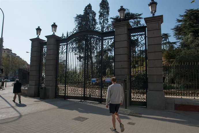 Transeúntes pasan frente a una de las entradas del Retiro