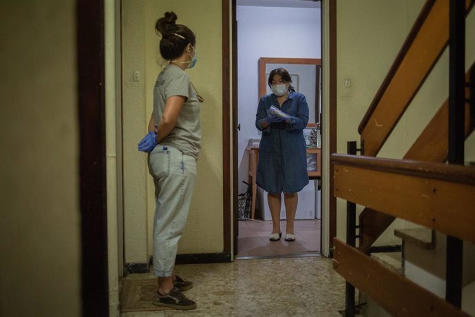 Una voluntria de l'ONG Proactiva Open Arms entrega a una dona material sanitari en plena crisi del Covid-19. A Barcelona, Catalunya, (Espanya), a 8 de maig de 2020.
