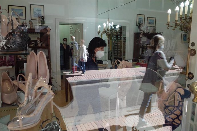 Una zapatería abierta en Zaragoza con clientes y dependientes con mascarilla