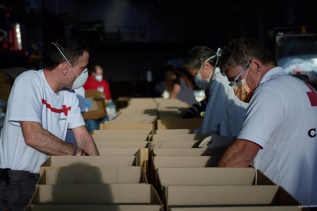 Voluntarios de Cruz Roja preparan lotes de comida
