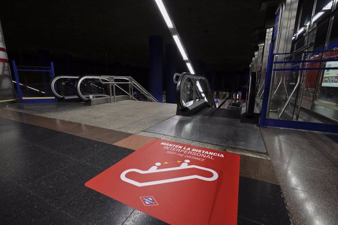 Señal en el suelo junto a las escaleras mecánicas en la que se recuerda mantener la distancia interpersonal en la estación de Metro de de Madrid de Mar de Cristal.