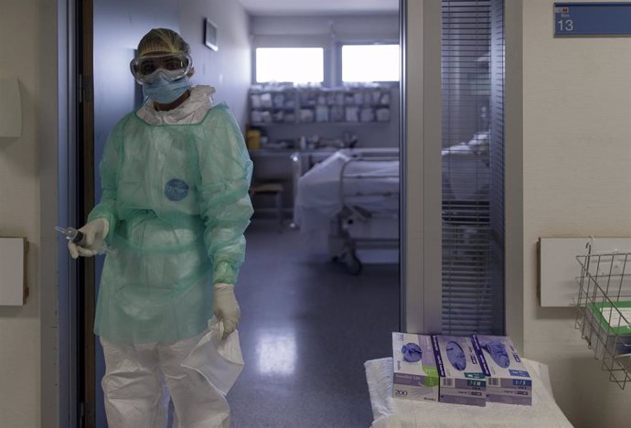 Un trabajador sanitario en la puerta de la habitación de un paciente ingresado en la Unidad de Cuidados Intensivos del Hospital Infanta Sofía en San Sebastián de los Reyes