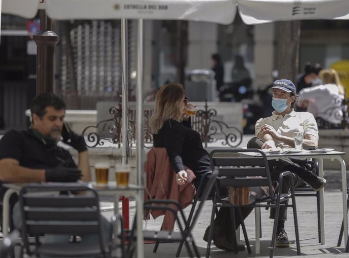 Varias personas en los veladores de un bar de Sevilla durante la Fase 1 del plan de desescalada del Gobierno.
