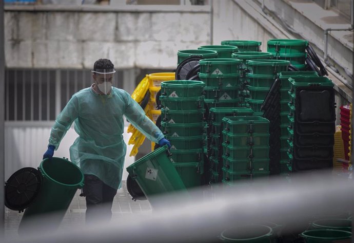 Un trabajador sanitario apila cubetas de residuos en el Hospital Virgen Macarena durante el día 34 del estado de alarma en el país por la crisis del coronavirus. En Sevilla (Andalucía, España), a 17 de abril de 2020.