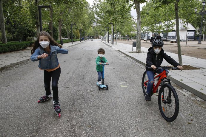 Tres nens practiquen esport a l'aire lliure protegits amb mascarillas, el primer dia en el qual els menors de 14 anys poden sortir. A Granada (Andalusia ,Espanya) a 26 d'abril de 2020.