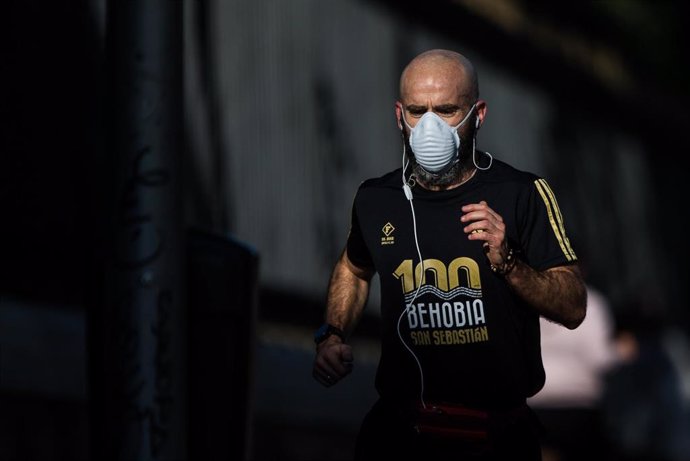 Un hombre protegido con mascarilla sanitaria hace deporte por la calle Alcalá de la capital 