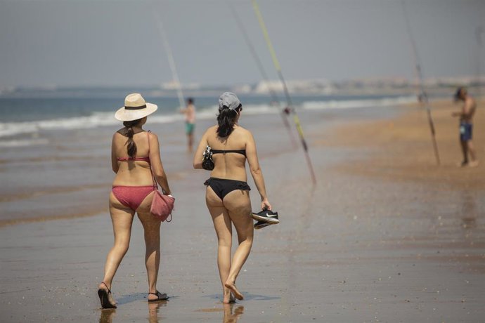 Dos personas pasean por la playa de Punta Umbría, durante la fase 1
