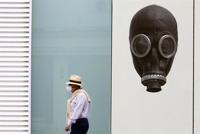 Un hombre camina cerca de la Plaza de Toros en Málaga, donde va protegido por una mascarilla por el virus COVID-19.- Málaga a 14 de mayo del 2020