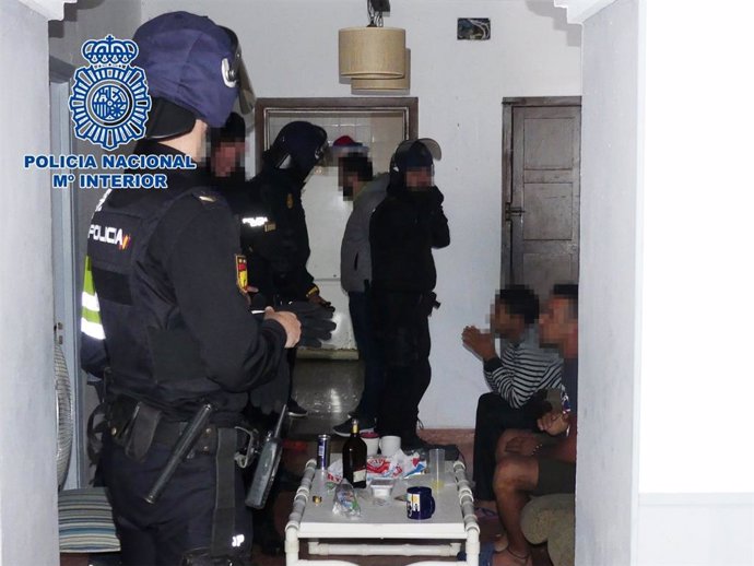 Agentes de policía en una vivienda con inmigrantes