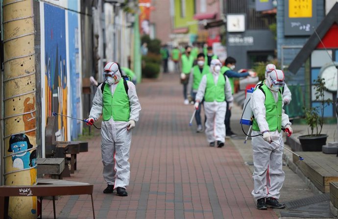 Un grupo de trabajadores desinfectan una calle de Corea del Sur.