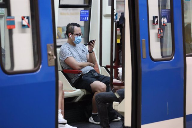 Varios pasajeros viajan dentro de un tren de Metro de Madrid, el mismo día de la presentación de una cámara térmica con la que se controlará la temperatura de los trabajadores del Puesto de Mando de Metro en el Puesto de Mando de la estación de Metro Alto