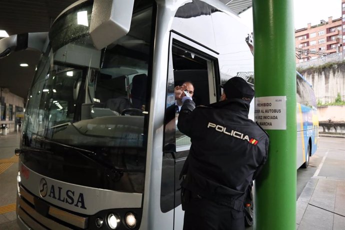 Agentes de la Policía Nacional entregan mascarillas en la estación de Oviedo, a 13 de marzo de 2020.