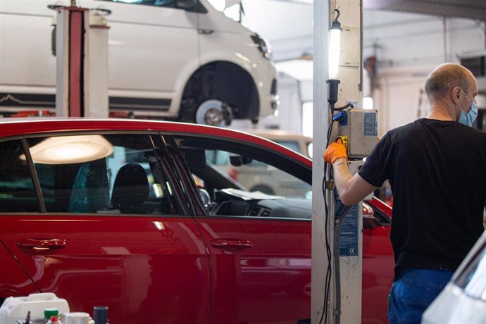 Un empleado manipula un vehículo en uno de los talleres que trabaja bajo cita previa y contando con un protocolo de seguridad e higiene