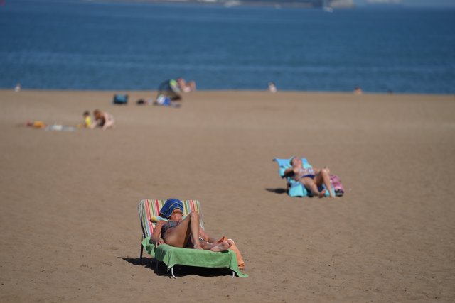 Varias personas toman el sol en la Playa de Ereaga en Getxo durante el primer día de la Fase 2, cuando se puede acceder a las playas de la misma provincia, isla o unidad territorial  En Getxo, Bilbao, Vizcaya, País Vasco (España), a 25 de mayo de 2020.