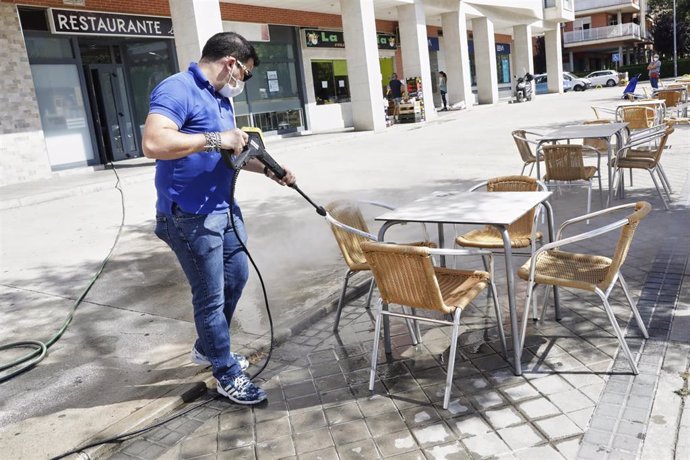 Un trabajador desinfecta la terraza de un restaurante antes de reabrir sus puertas 
