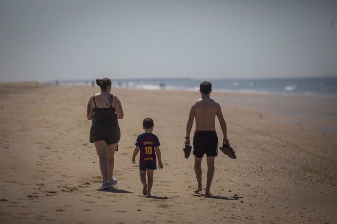Una familia pasea por la Playa de Punta Umbría durante la fase 1 de la desescalada