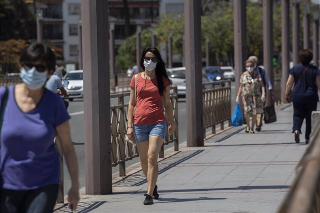 Varias personas con mascarilla y ropa veraniega durante un "episodio de altas temperaturas". Según la calificación de la  Agencia Estatal de Meteorología (AEMET). En Sevilla,(Andalucía, España), a 22 de mayo de 2020.