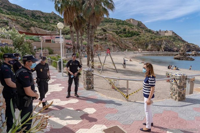 La alcaldesa, en Cala Cortina, con los policías locales que vigilan el acceso a la playa durante el primer día de apertura