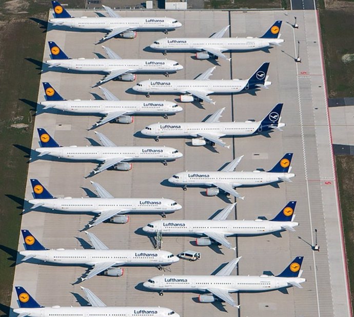 FILED - 26 March 2020, Brandenburg, Schoenefeld: Lufthansa aircraft are parked on the grounds of the Berlin-Brandenburg (BER) airport off the runway. 

