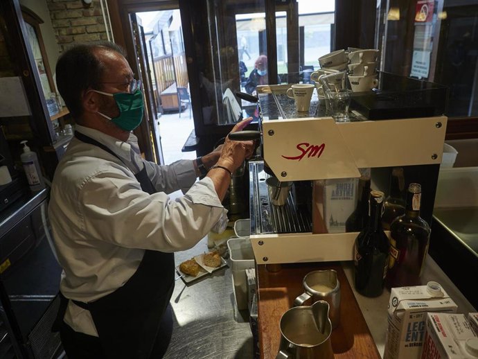 Un camarero en la barra de un bar el día en el que se reabren al público los establecimientos de hostelería y restauración para consumo en el local.
