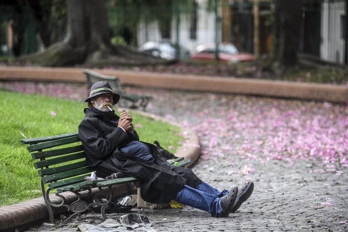 Un hombre se echa un cigarro en un banco de un parque de Buenos Aires a pesar de las restricciones impuestas por el Gobierno de Argentina durante la crisis de la COVID-19.