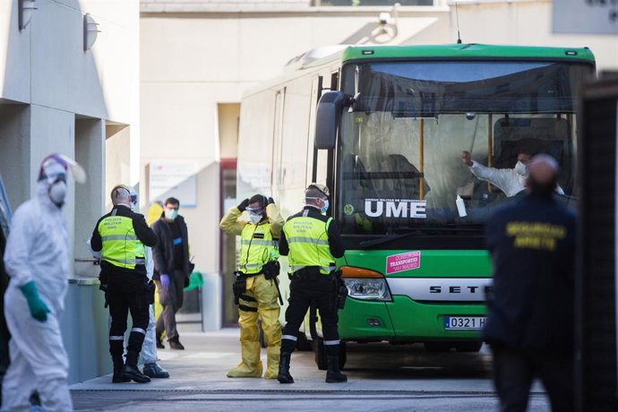 Efectivos de la UME desinfectan en las inmediaciones de Urgencias del Hospital Gregorio Marañón uno de los autobuses interurbanos puestos a su disposición por el Consorcio Regional de Transportes.