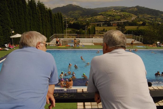 Dos personas mayores, frente a una piscina