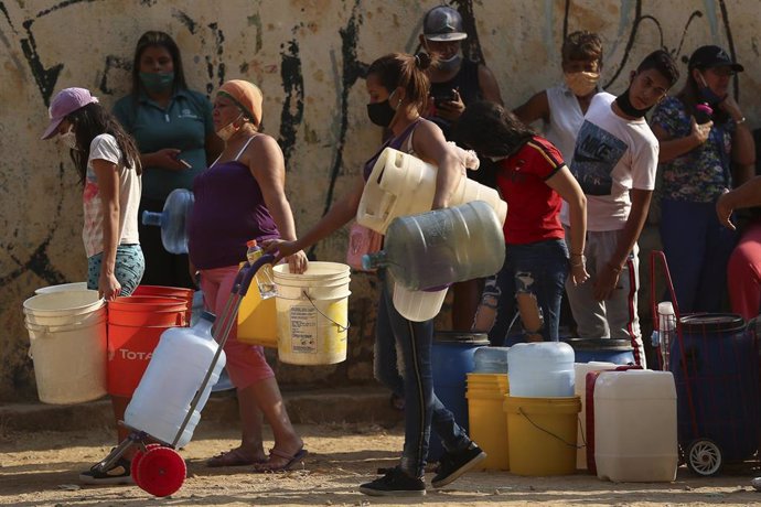Personas esperan para recoger agua en Caracas ante los cortes de suministro