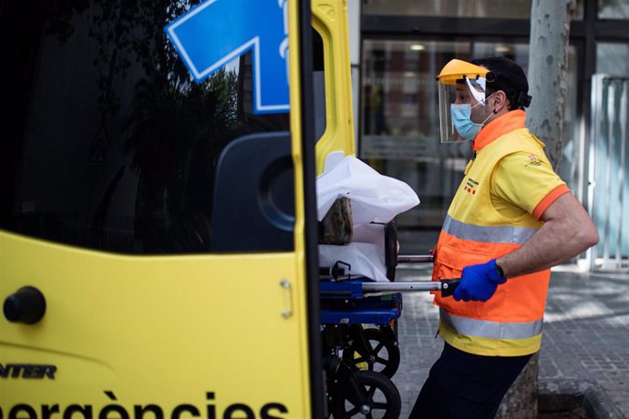 Un técnico del Sistema de Emergencias Médicas (SEM) de la Generalitat de Cataluña mete una camilla en una ambulancia durante un servicio y limpieza de EPIs, en Barcelona/Catalunya (España) a 19 de abril de 2020 (archivo).