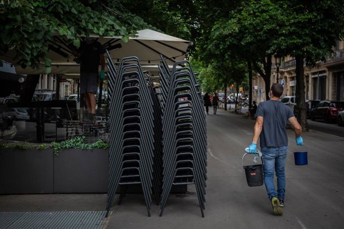 Un hombre pasa junto a la terraza de un bar durante el primer día de la Fase 1. En Barcelona, Catalunya (España), a 25 de mayo de 2020.