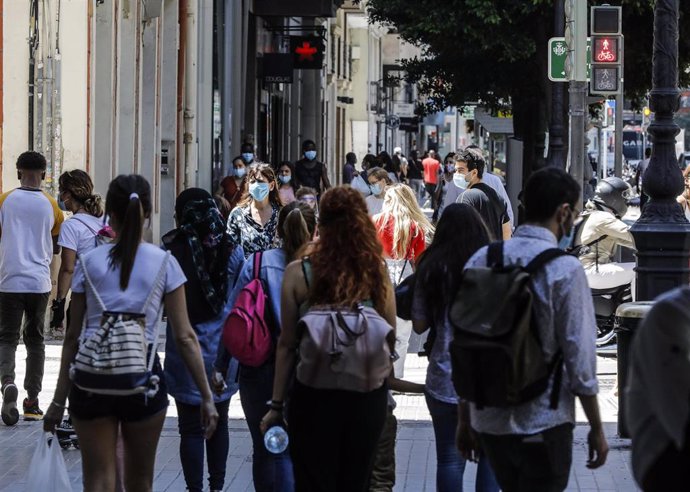 Varias personas caminan por una calle del centro de Valencia después de que el Ministerio de Sanidad autorizara a que la totalidad de la Comunidad Valenciana pasase en su conjunto a la fase 1 de la desescalada (archivo)