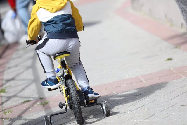 Un niño monta en bicicleta en la ciudad de Madrid.