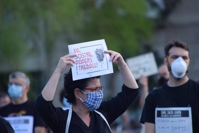 Una mujer con mascarilla en la concentración en la plaza Universitat de Barcelona convocada bajo el lema 'La vida antes que el capital'.