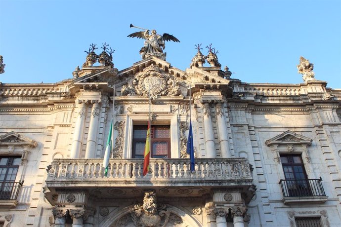 Banderas a media asta en la fachada principal de la Universidad de Sevilla, que se suma al luto oficial de diez días por las víctimas del coronavirus.