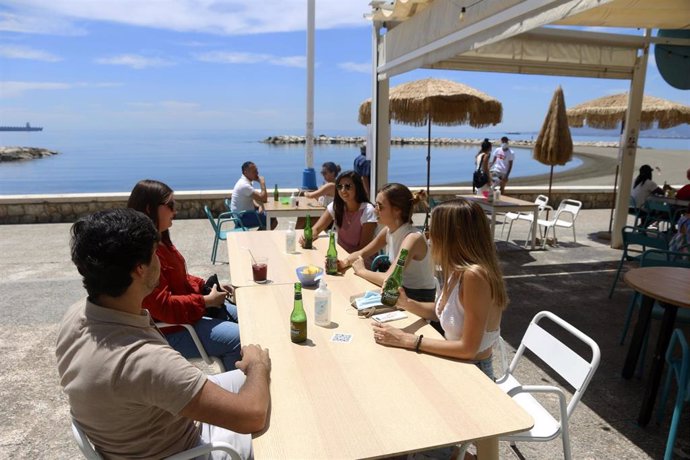 Varias personas disfrutan de la terraza de un bar en el paseo marítimo de Pedregalejo durante la Fase 1 en Málaga a 20 de mayo del 2020