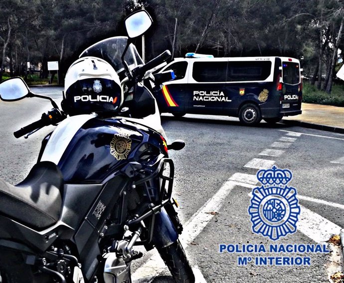 Imagen de una moto y un furgón de Policía Nacional