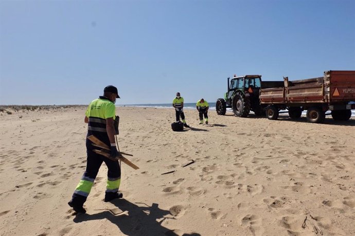 Operarios acometen la limpieza en la playa del Espigón de Huelva.