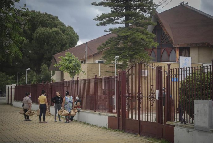 Un grupo de mujeres conversa en la calle tras una entrega de alimentos en el Polígono Sur