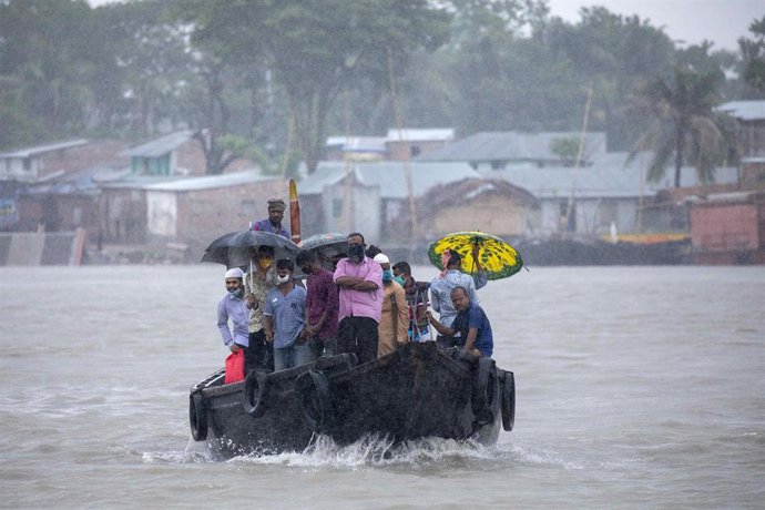 Una embarcación con pasajeros cruzando un río en Bangladesh horas antes de la llegada del ciclón 'Amphan'