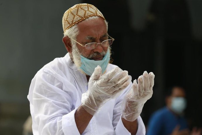 Un hombre musulmán con mascarilla y guantes reza en el Eid al Fitr en Daca, la capital de Bangladesh