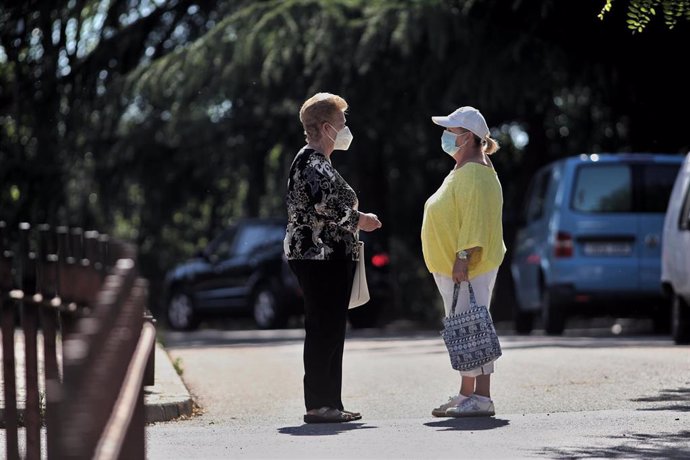Dos mujeres protegidas con mascarilla mantienen una conversación en una de las calles del municipio de Griñón (Madrid) durante el día 69 del estado de alarma decretado a consecuencia del coronavirus y todavía fase 0 de la desescalada instaurada por el G