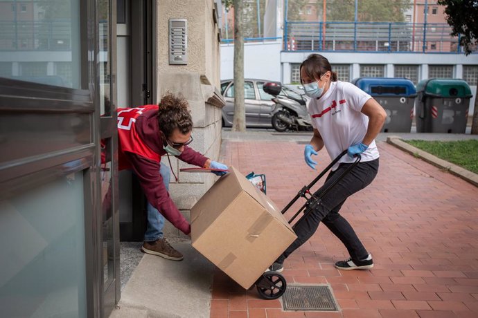 Diversos voluntaris de Creu Vermella reparteixen caixes amb aliments i productes per ajudar a totes aquelles persones que puguin veure's afectades per la crisi sanitria. A Barcelona, Catalunya, (Espanya), a 9 d'abril de 2020.