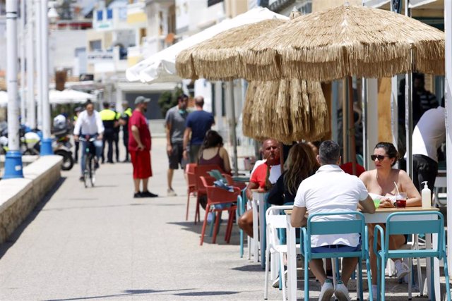 Un grupo de personas pasean por el paseo marítimo de Pedregalejo  durante la Fase 1 en Málaga a 20 de mayo del 2020