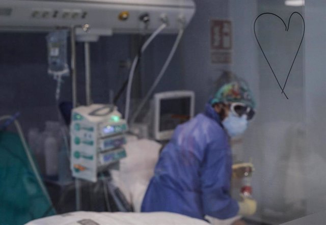 Trabajadores sanitarios totalmente protegidos atienden a un paciente con coronavirus ingresado en la UCI del Hospital Arnau de Vilanova, en Valencia, Comunidad Valenciana, (España), a 24 de abril de 2020.