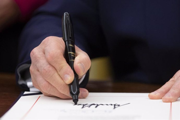 Donald Trump firmando una orden ejecutiva. 