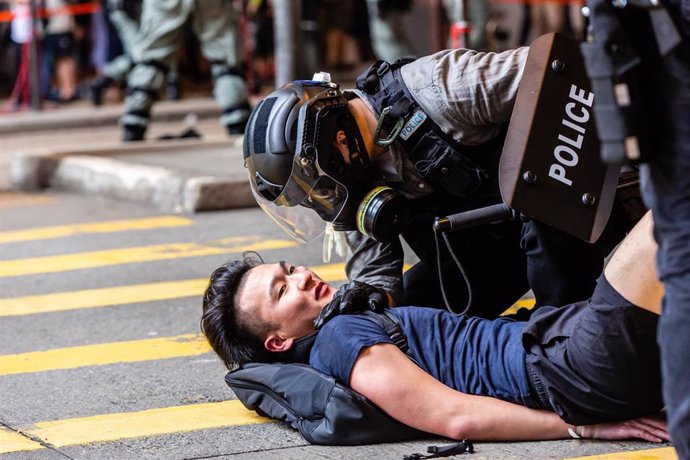 Un agente de  Policía arroja a un manifestante al suelo durante un mitin. Pekín está presionando para implementar nuevas leyes de seguridad nacional y leyes antisedición en nombre de la ciudad y eludiendo la legislatura de Hong Kong.  