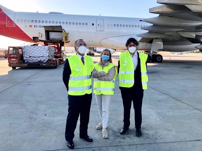 La secretaria general de Fenin, Margarita Alfonsel; el presidente ejecutivo de Grupo Oesía, Luis Furnells, y el director de Ventas de Iberia, Guillermo González, recibiendo el material sanitario del corredor.