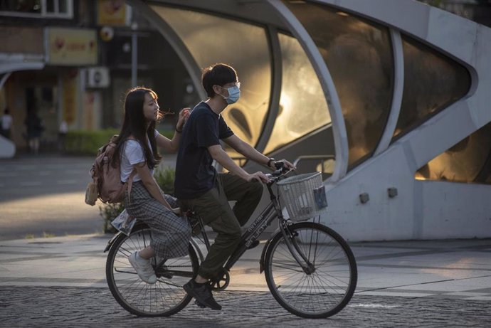 Dos personas en bicicleta en una calle de Taipei