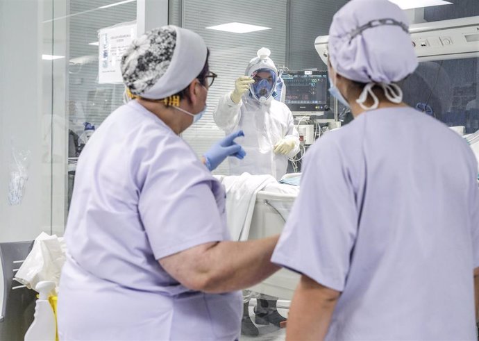 Trabajadores sanitarios totalmente protegidos atienden a un paciente con coronavirus ingresado en la UCI del Hospital Arnau de Vilanova al inicio de la pandemia