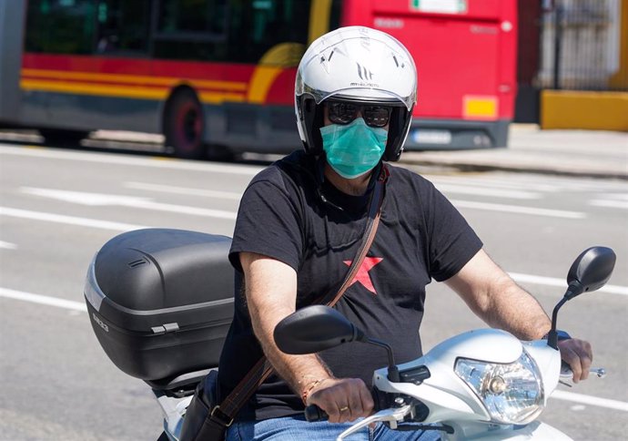 Un motorista con mascarilla  en el  primer día del uso obligatorio de mascarillas por el Covid-19. Sevilla a 21 de mayo del 2020